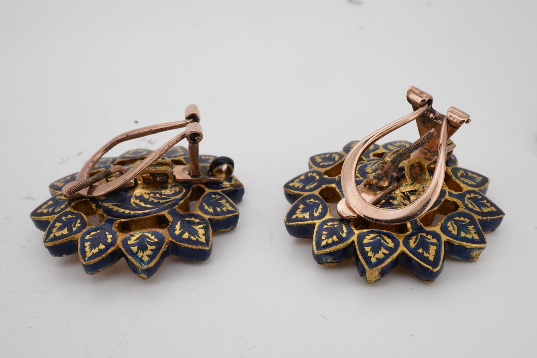 Two pairs of Indian enamelled earrings, comprising: one of chandelier design, set with rock crystals and applied with blue, white and red enamel, suspending a fringe of cultured pearls and blue and red pastes, length 5.1
